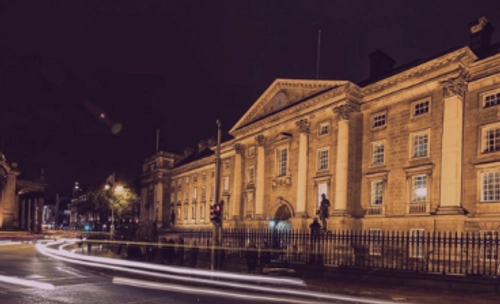 A night photo of the front facade of Trinity College Dublin
