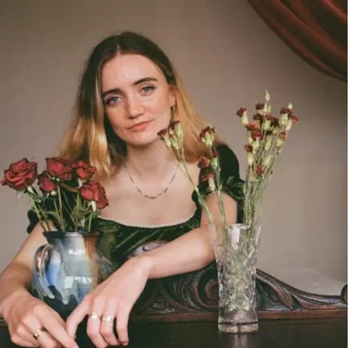 Trinity College student Róisín Ní Haicéid sitting with flowers