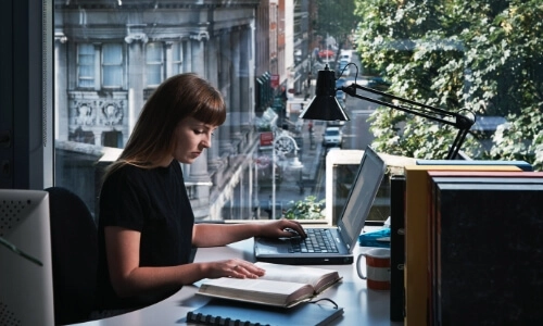 Student in Library with a window view of Dawson Street