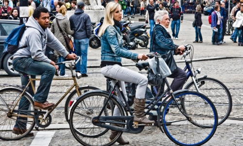 Three cyclists stopped at traffic lights in Copenhagen.