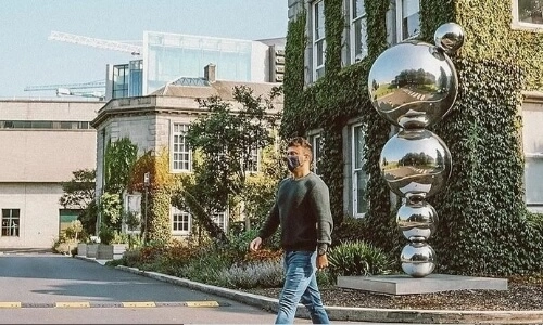 A person walking through the Trinity campus