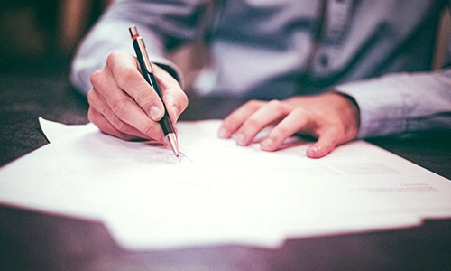 hands signing papers