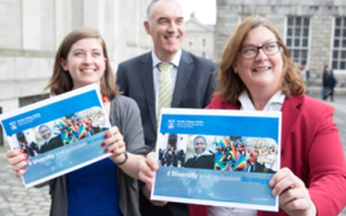 Three people holding up the Diversity and Inclusion Strategy booklet