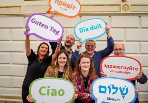 Colleagues from the School of Languages, Literatures and Cultural Studies holding greeting signs in the languages taught in the School.