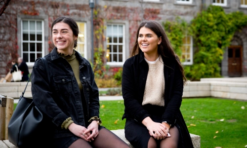 Two students seated on Trinity campus.