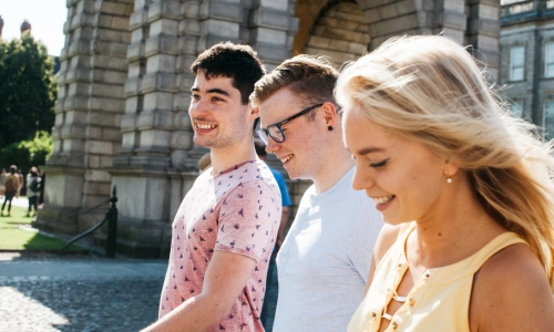 A group of students walking past the Campanile (bell tower).