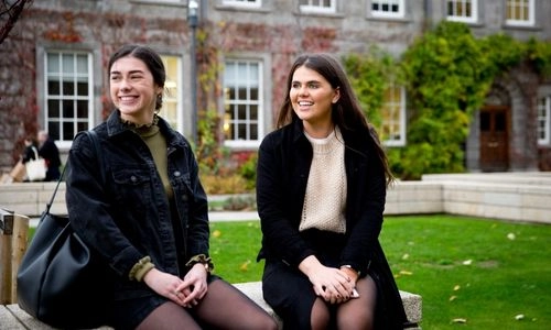 Two students seated on Trinity campus.
