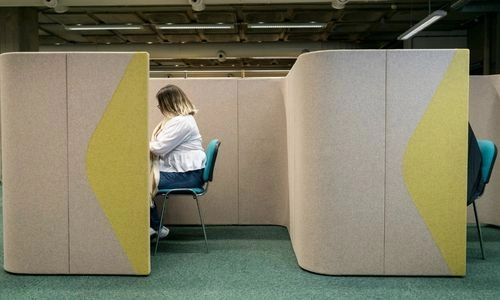 A person using a private study cubicle in the Ussher Library.