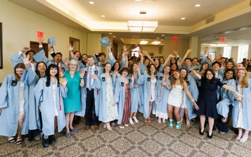 A group of Dual BA students wearing graduation robes.
