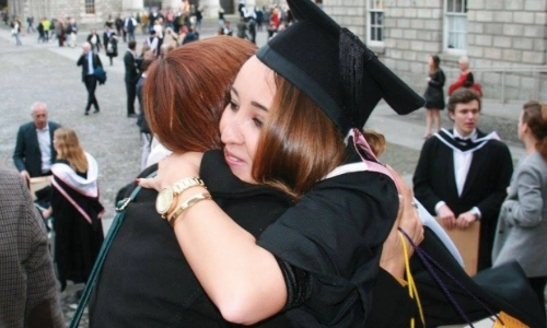 Two students hugging and celebrating their graduation