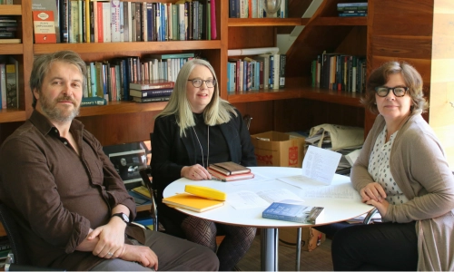 Three people seated at a circular table