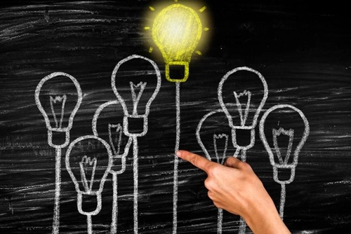 Chalk drawing image of light bulbs the top most fully lit