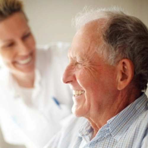 A healthcare professional smiling and talking to an older person