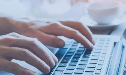 A close up image of someone typing on a keyboard