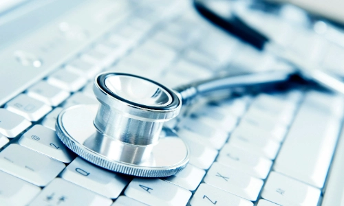 A stethoscope lying on top of a keyboard