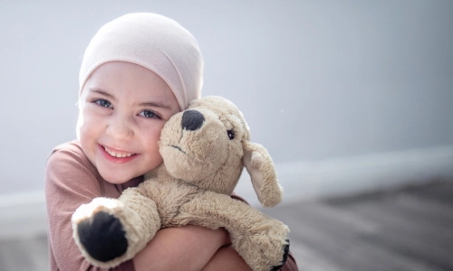 Child with cancer hugs teddy