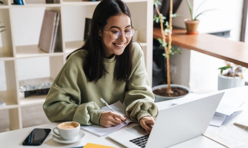 A girl with coffee and an open laptop