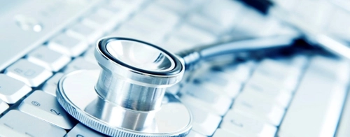 A stethoscope lying on keys of a keyboard