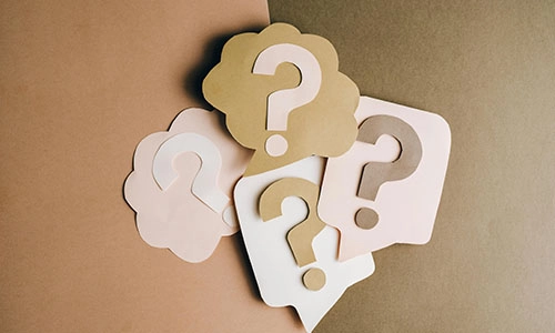 Question marks on cards on a brown background