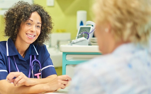 Smiling nurse talking with patient