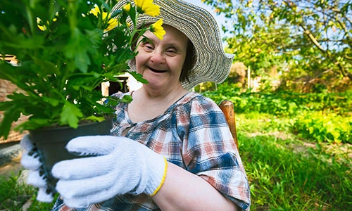 appy woman with Down Syndrome ready to planting flowers. Gardening.
