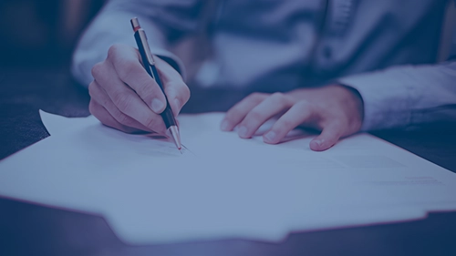 A person completing a research contract on paper.