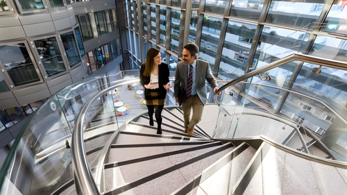 Two education professionals walking up a spiral staircase
