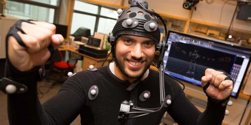 A person in a body suit with data fed into a computer