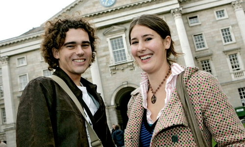 two students standing in front of the front of Trinity College Dublin
