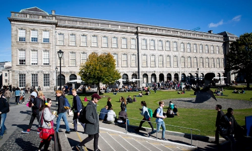 Front Square of Trinity College with lots of students sitting in the sunshine