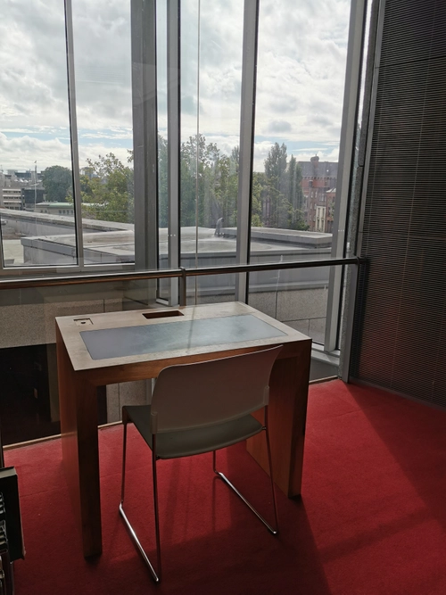 A desk on a high floor of a Trinity library, with a view of a roof
