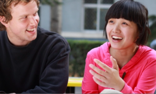 two people chatting about a book they have open
