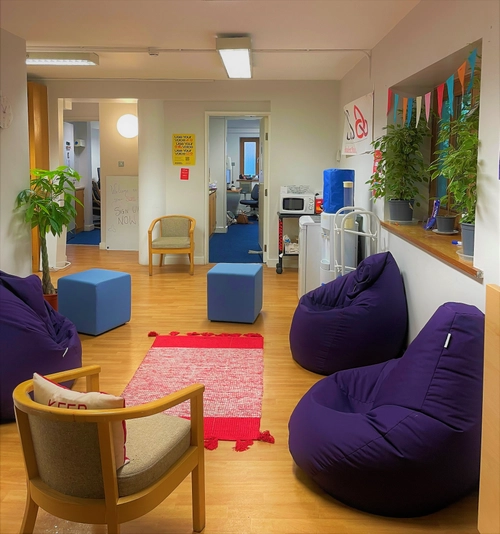 A room with chairs and beanbag chairs in a circle