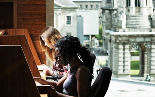 Students studying with campanile in background