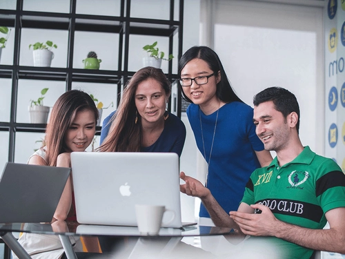 Students sitting around a laptop