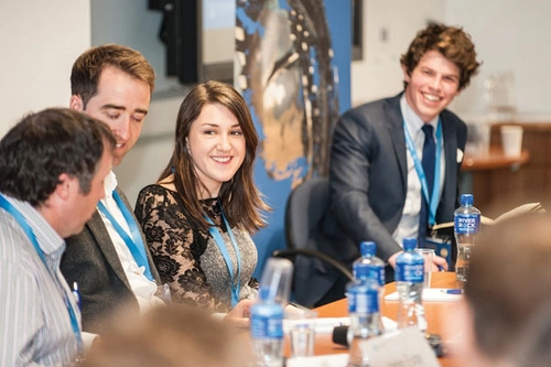 Four graduates talking at a boardroom table