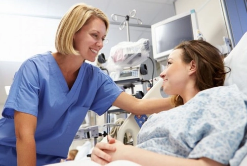 Doctor visiting patient in hospital ward