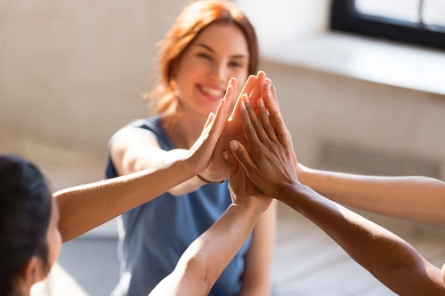 Woman patting hands with a group