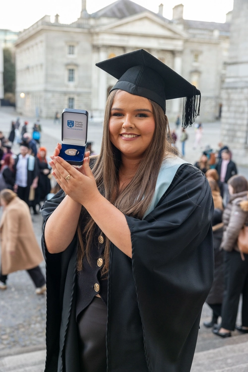 Student in cap and gown with academic medal