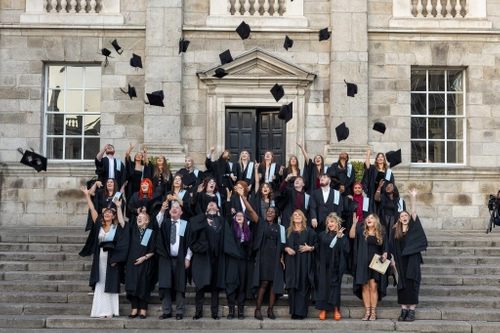 students throwing graduation caps in air
