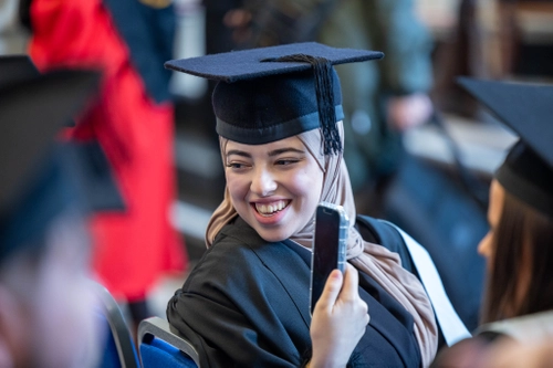 Young woman in cap and gown graduation