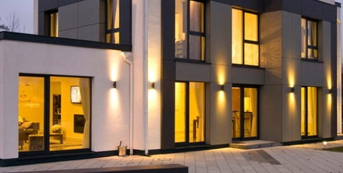 an image of an innovative house with lights on set in the evening