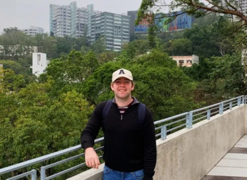 Daryl Egan standing against a background of the Hong Kong skyline