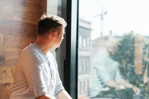 Student looking out a window from Trinity's Long Room Hub