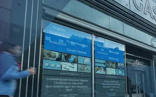 Exterior image of the School of Nursing and Midwifery building with a person walking into the shot