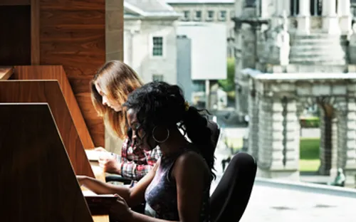 Students studying with campanile in background