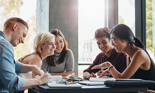 students sitting around a white table
