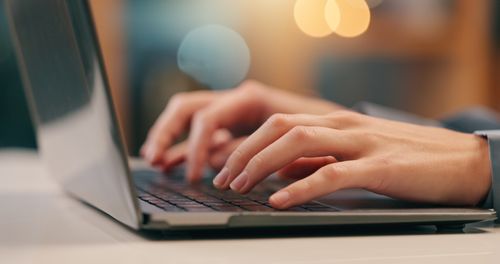 Online Assessment - hands typing on laptop