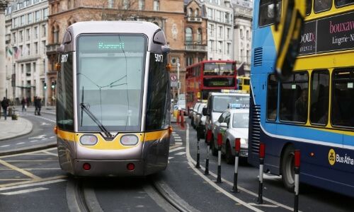 A Luas tram and a bus outside College Green