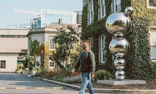 A person walking through the Trinity campus